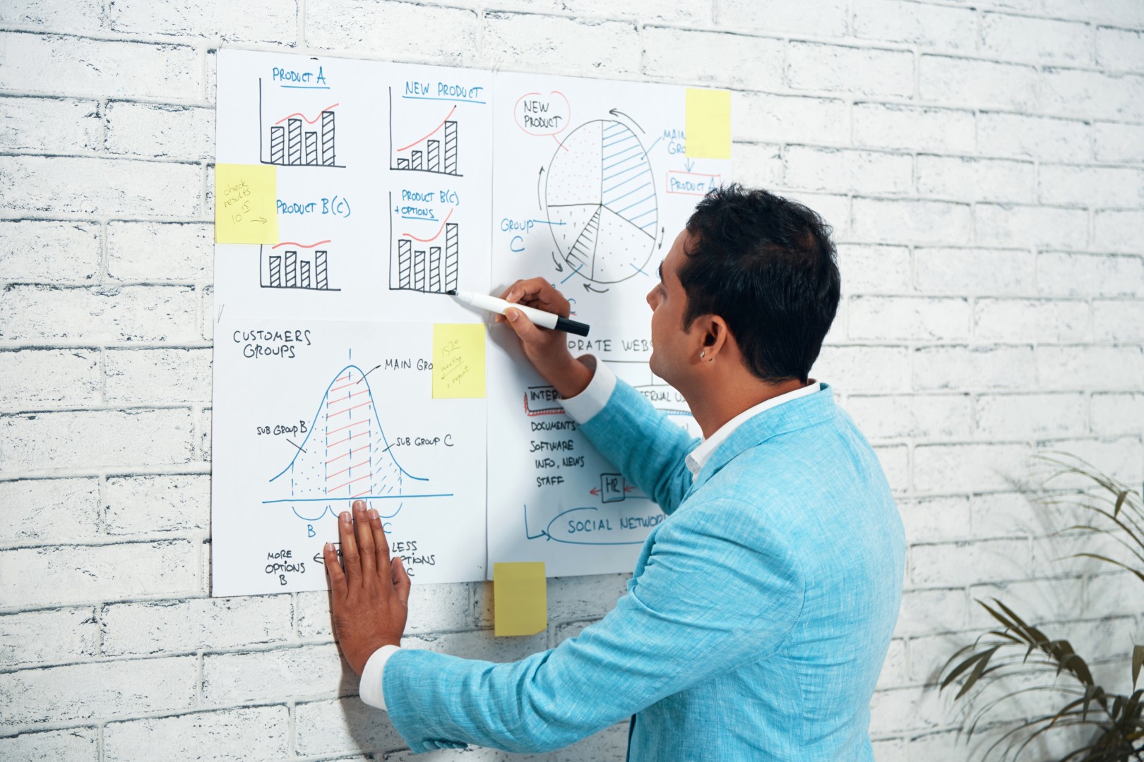 au-dessus-de-l-epaule-d-un-homme-d-affaires-dessinant-des-diagrammes-sur-l-affiche-murale (Grande)